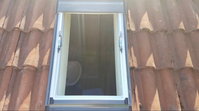 Neu eingebautes Velux Dachfenster in roten Dachziegeln nach einer Renovierung
