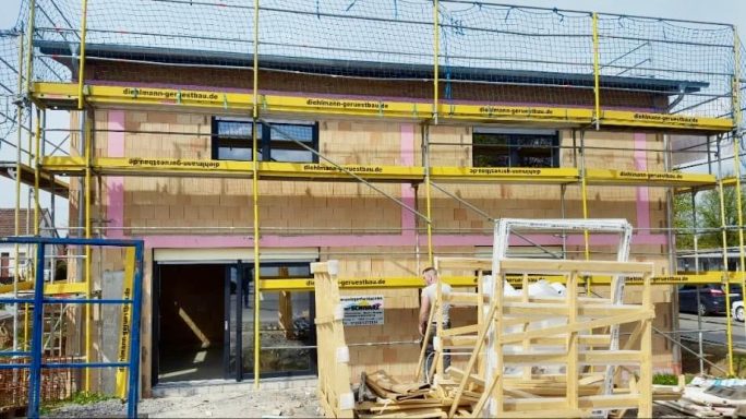 Haus im Bau mit Gerüst von diehlmann-geruestbau.de, offener Eingangsbereich, Fenster montiert.